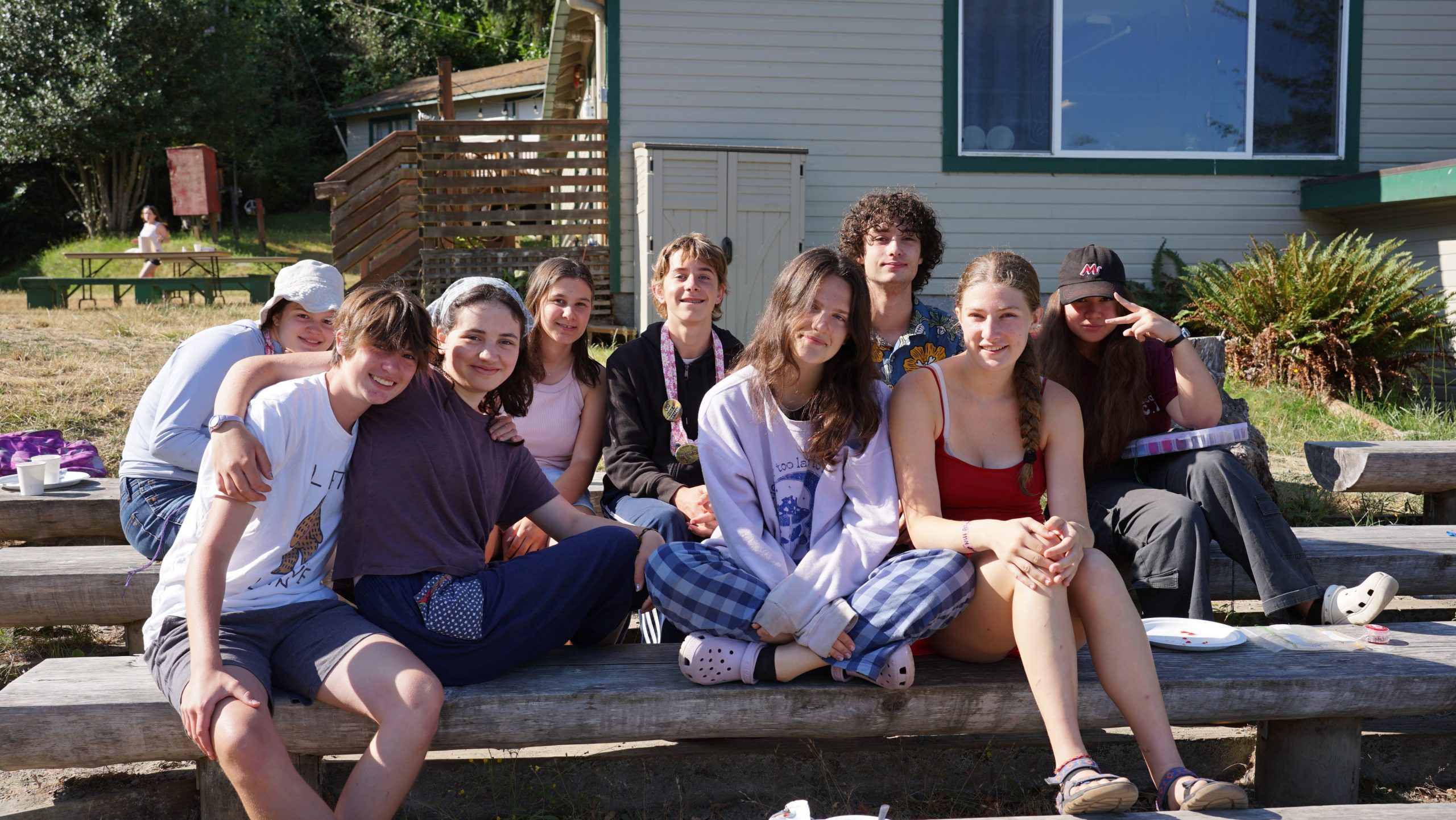 a group of counselors in training sitting at green circle striking many smiles