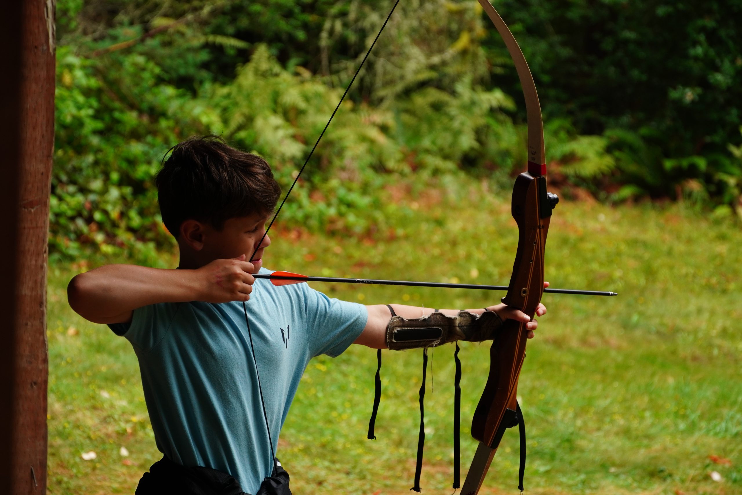 camper with bow and arrow aiming for a bullseye