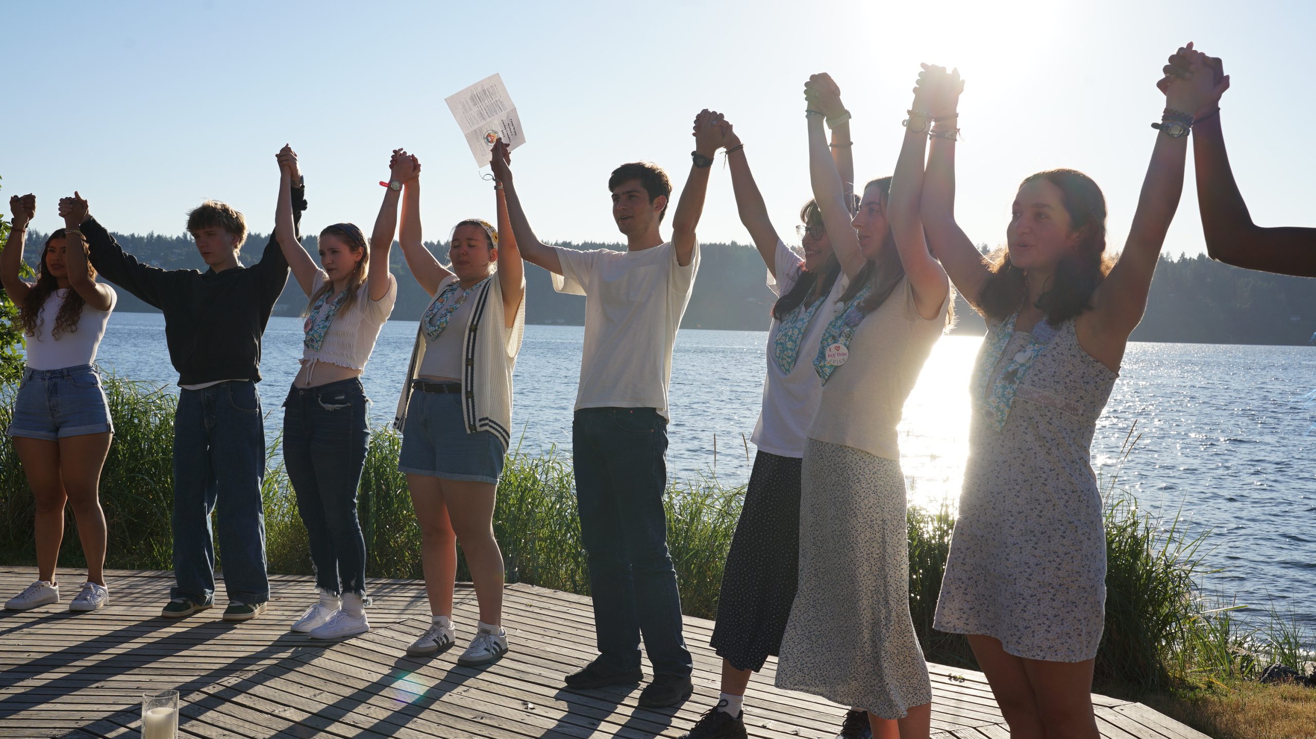 a group of staff holding hands raised in the air celebrating