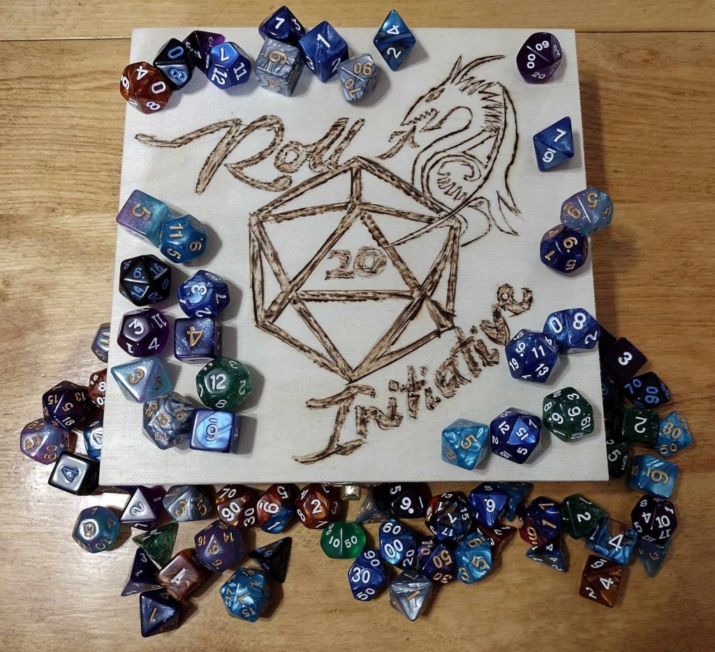 a large collection of multi sided dice used in dungeons and dragons games sitting on top of a small sign that reads 'roll initiative' around a twenty sided die that has a value of 20
