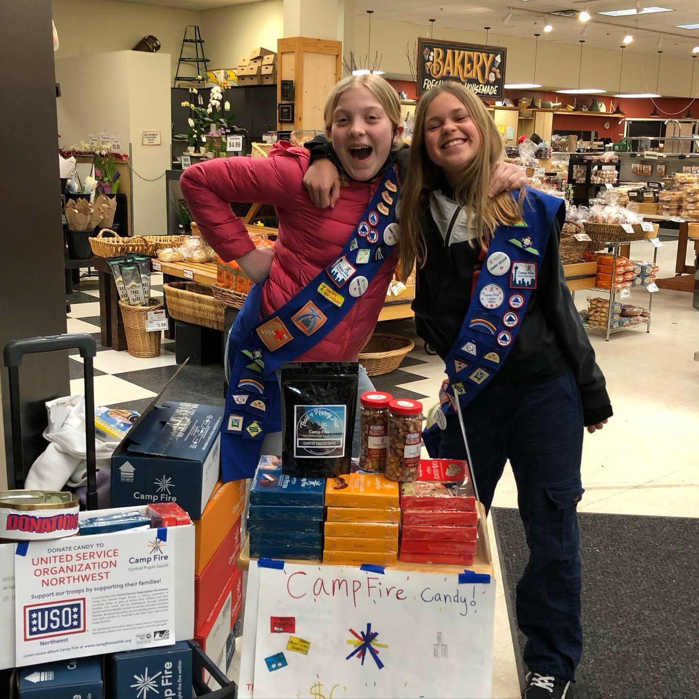 two girls showing off sashes filled with patches