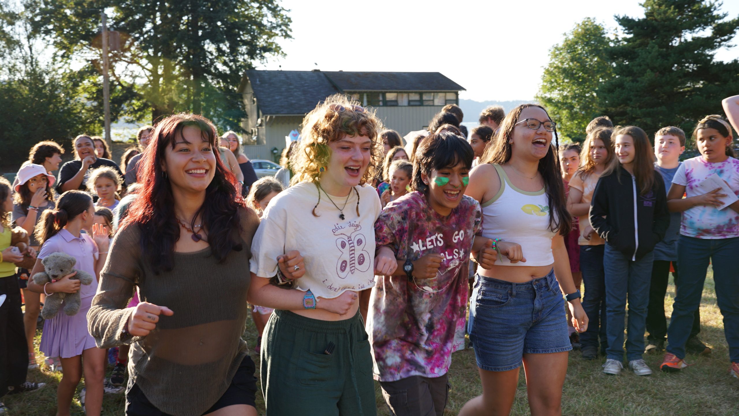 summer staff walk arm in arm smiling and laughing