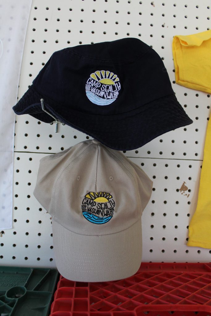 Navy blue and tan hats with embroidered Camp Sealth logos