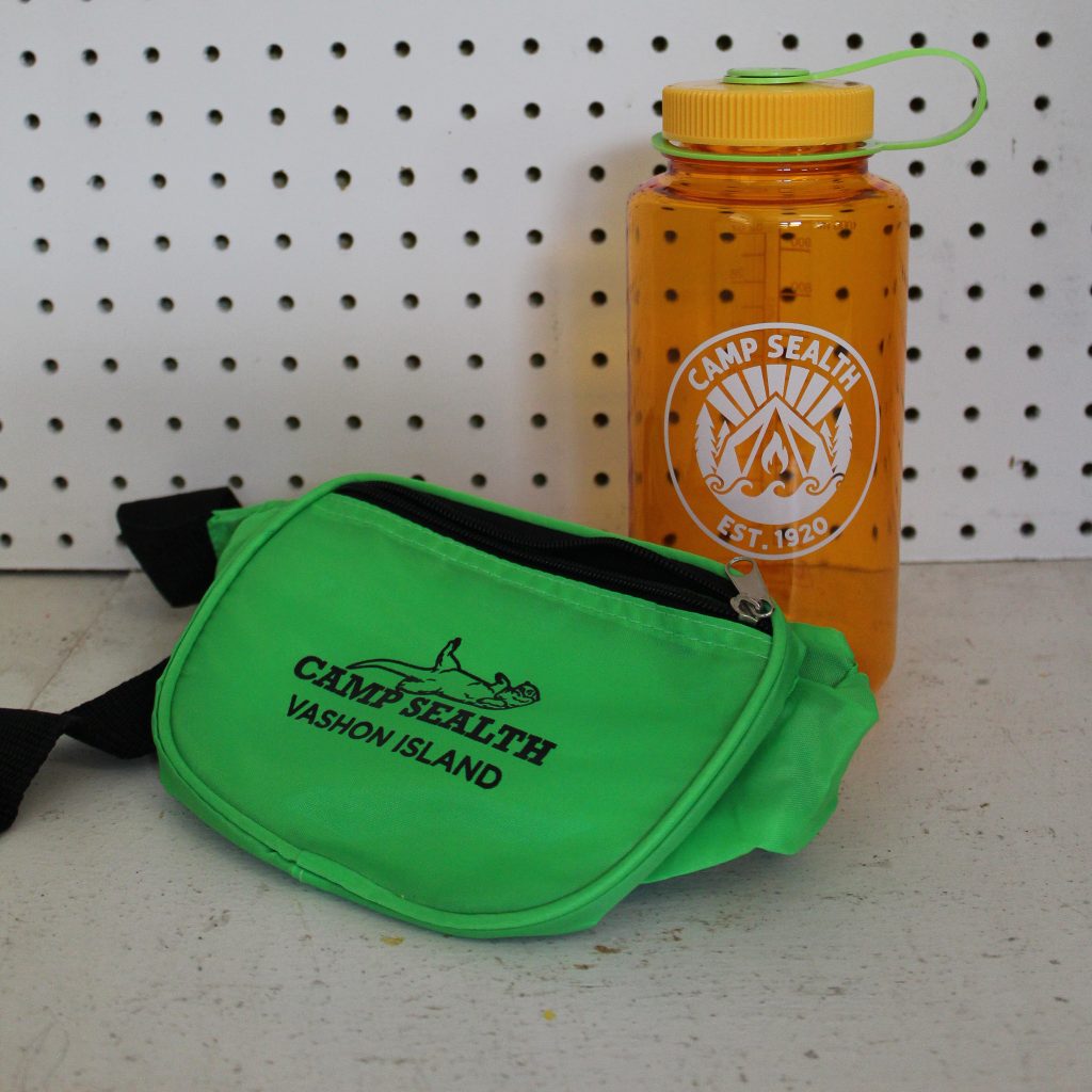 A green fanny pack and orange water bottle with the Camp Sealth logo