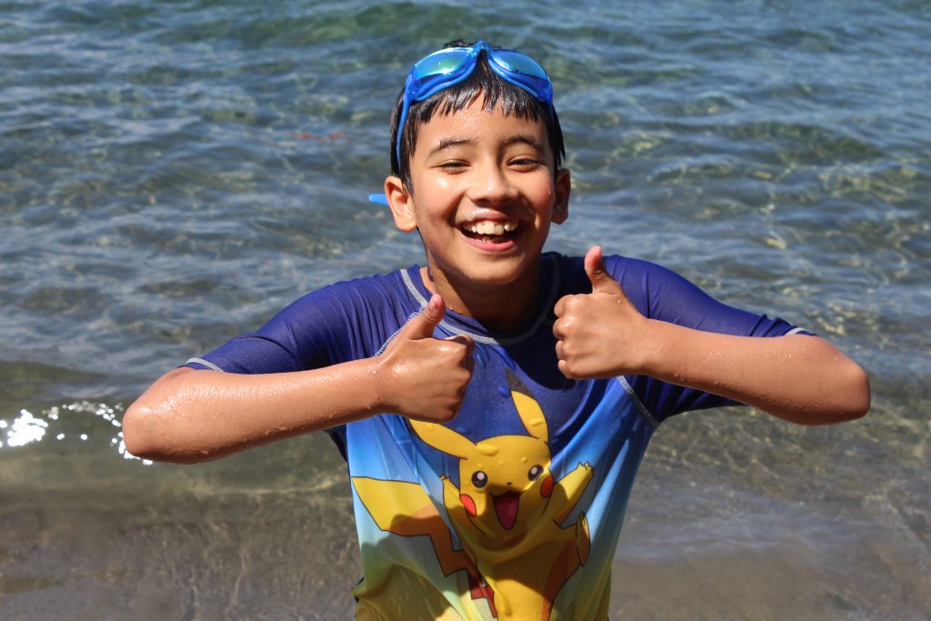 camper in water with two thumbs up