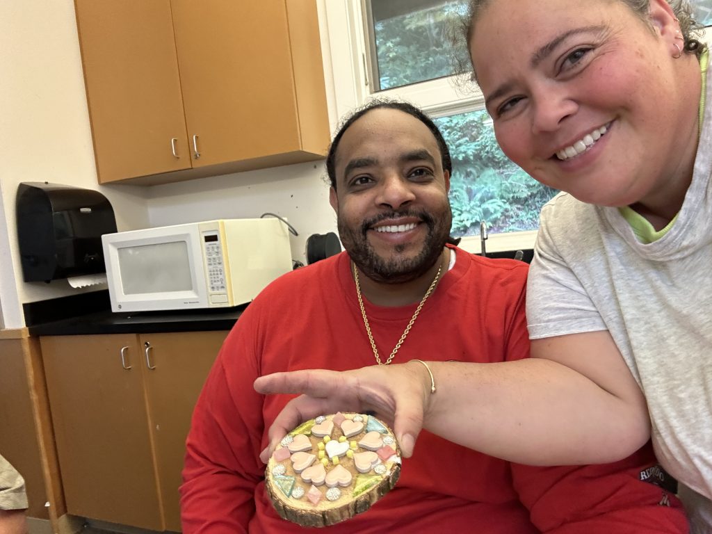 A man and woman showing off a crafted item