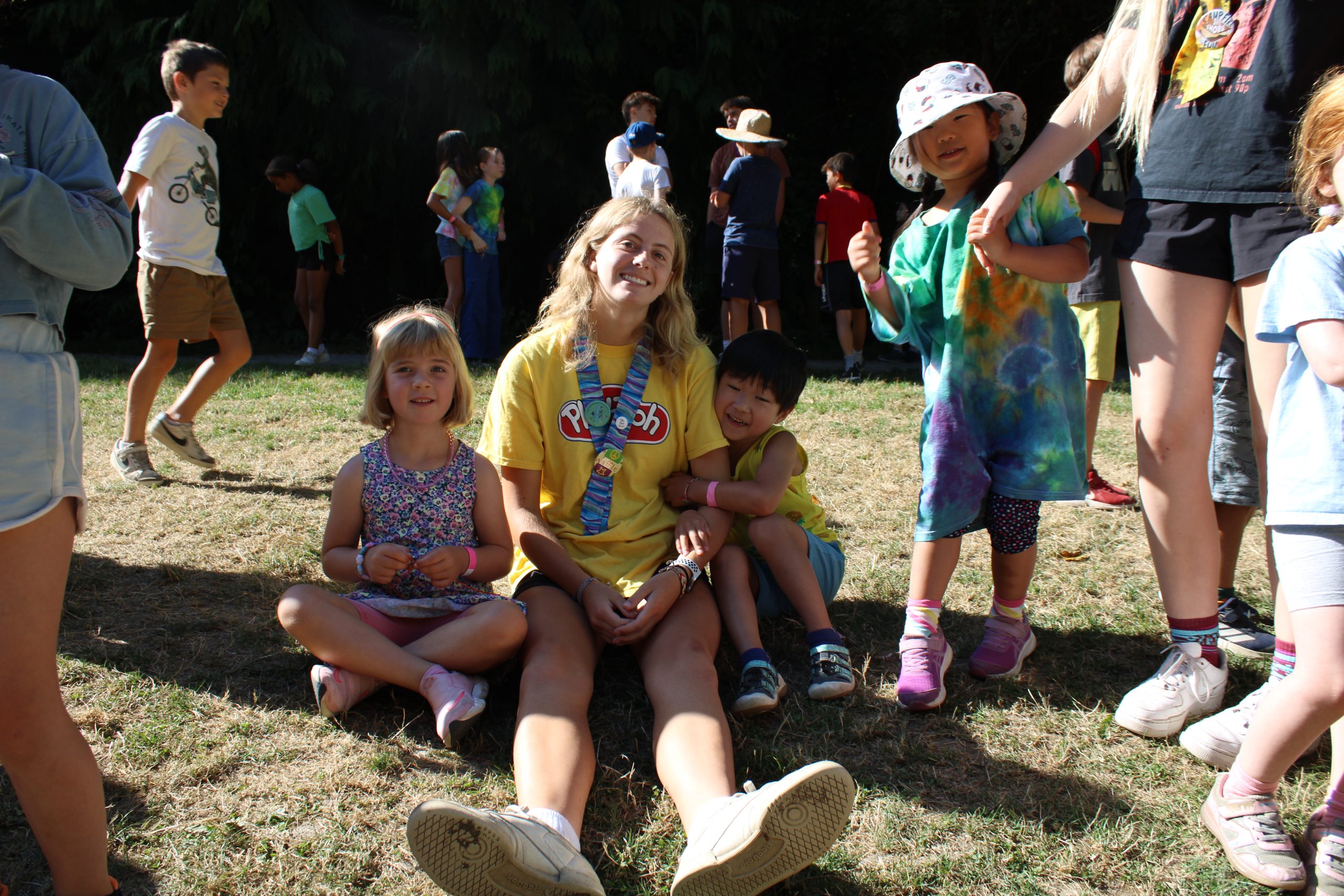 Day Camp staff with three campers gathered around her