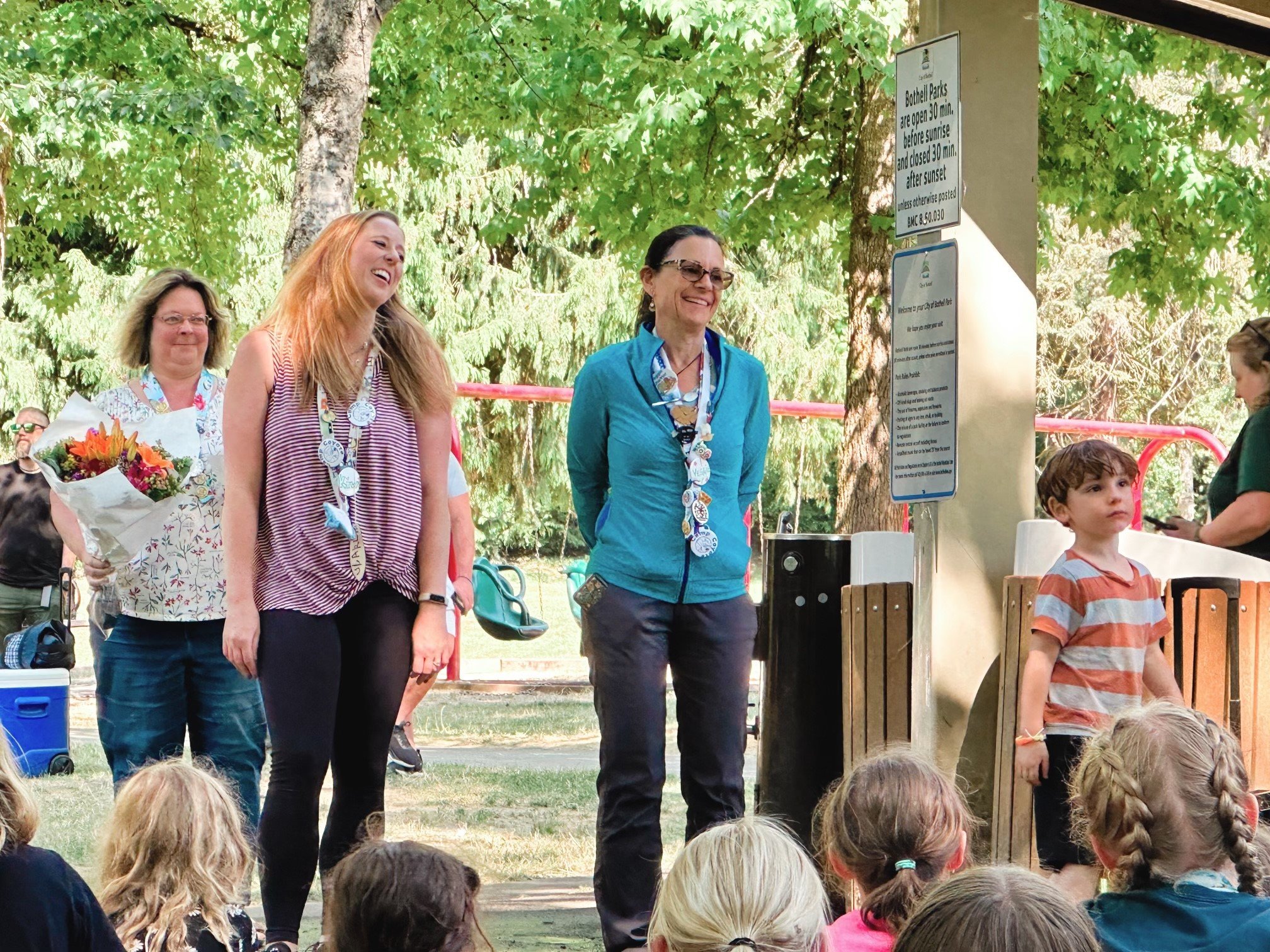 3 adults standing in front of a group of kids