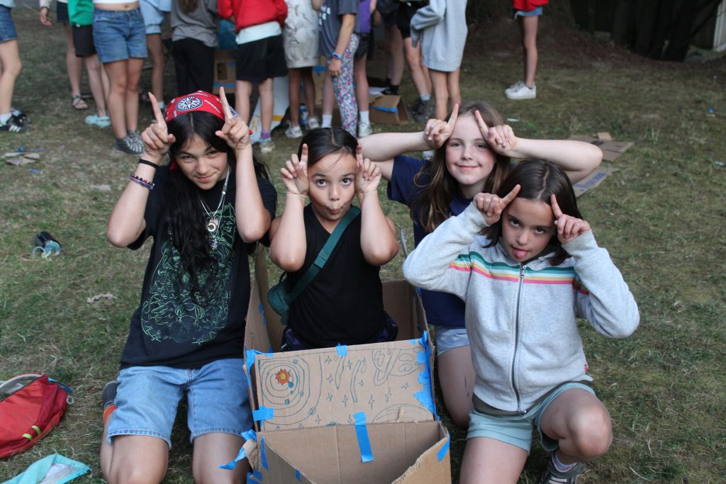 a group of kids making silly faces and using their fingers as antennas